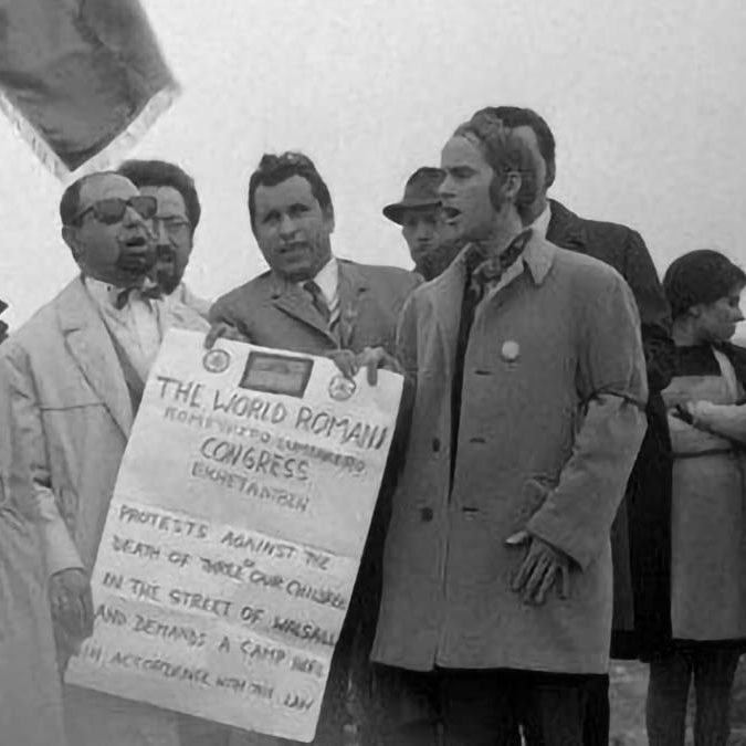 Participants au premier congrès mondial rom, tenu à Londres en 1971, chantant l’hymne « Gelem, gelem » (dont les paroles ont été écrites par Jarko Jovanović revêtu, sur la photo, d’un manteau blanc). Jan Čibula (à l’extrême gauche) deviendra le premier président de l’Union rom internationale et Grattan Puxon (à l’extrême droite) jouera un rôle de premier plan pendant le deuxième congrès. Walsall, 1971. Derrière (à gauche et à droite), on distingue Ladislav Demeter, Vanko Rouda et Juan de Dios Ramirez.